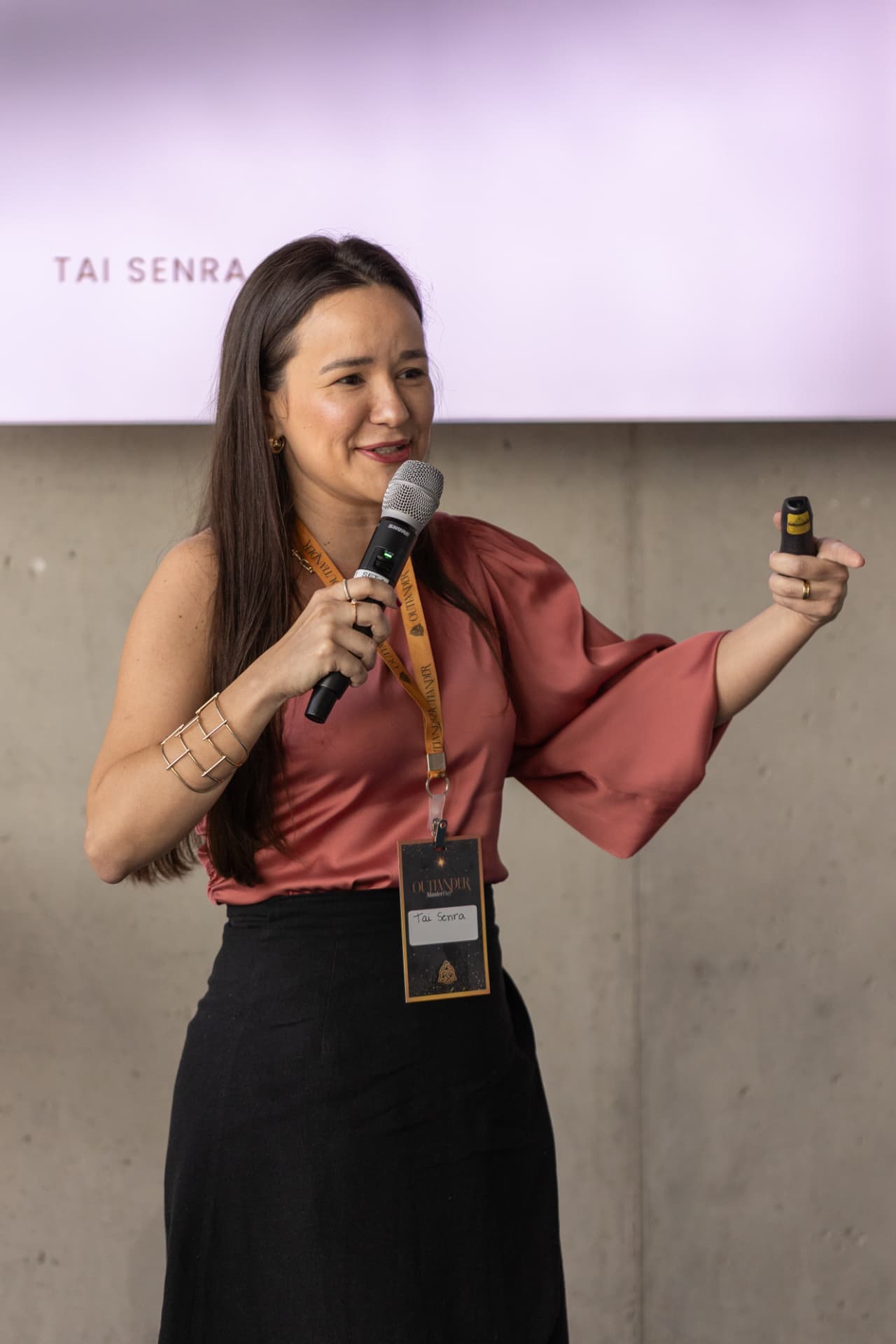 Tai Senra dando uma palestra com o microfone